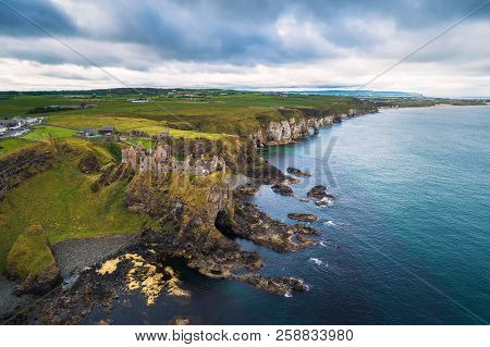 Aerial View Of The Medieval Dunluce Castle Ruins And Surrounding Cliffs In Ireland