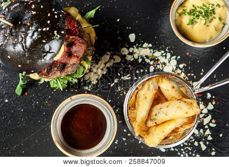Burger And Friench Fries On Black Stone Table , Cheese Tomato And Soia Sos