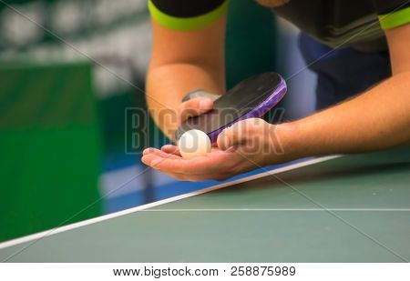 Table tennis player serving, close up