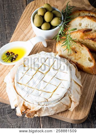 Baked Camembert Cheese. Fresh Brie Cheese And A Slice On A Wooden Board With Nuts, Honey, Rosemary, 