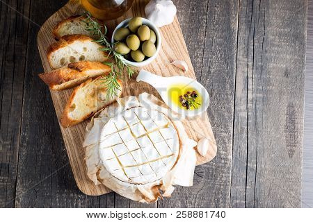 Baked Camembert Cheese. Fresh Brie Cheese And A Slice On A Wooden Board With Nuts, Honey, Rosemary, 