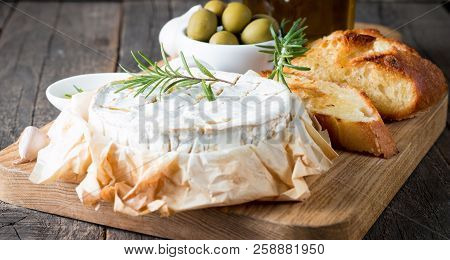 Baked Camembert Cheese. Fresh Brie Cheese And A Slice On A Wooden Board With Nuts, Honey, Rosemary, 
