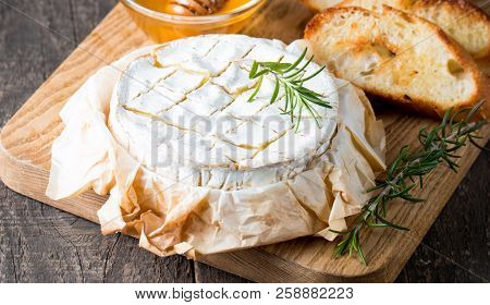 Baked Camembert Cheese. Fresh Brie Cheese And A Slice On A Wooden Board With Nuts, Honey, Rosemary, 