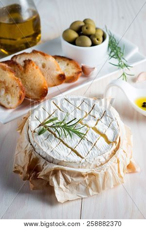 Baked Camembert Cheese. Fresh Brie Cheese And A Slice On A Wooden Board With Nuts, Honey, Rosemary, 