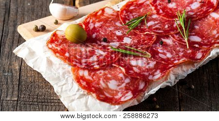 Chorizo Sausage And Salami, Thin Cut. Spanish Salami On The Wood Background With Spices, Paprika, Pe
