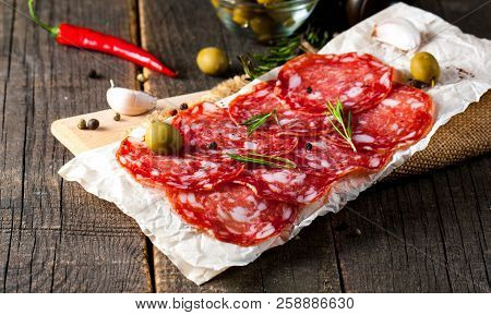 Chorizo Sausage And Salami, Thin Cut. Spanish Salami On The Wood Background With Spices, Paprika, Pe