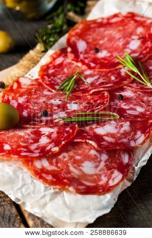 Chorizo Sausage And Salami, Thin Cut. Spanish Salami On The Wood Background With Spices, Paprika, Pe