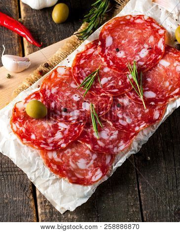 Chorizo Sausage And Salami, Thin Cut. Spanish Salami On The Wood Background With Spices, Paprika, Pe