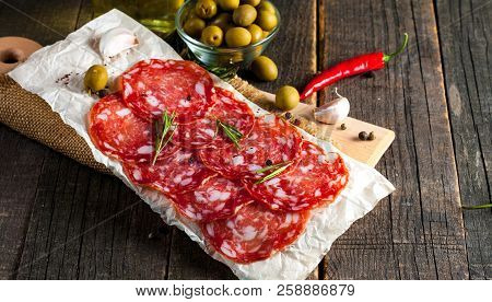 Chorizo Sausage And Salami, Thin Cut. Spanish Salami On The Wood Background With Spices, Paprika, Pe
