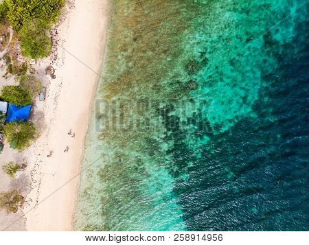 Aerial drone view of Petit Tabac tropical island, turquoise Caribbean sea of Tobago cays, and a family with kids in St Vincent and Grenadines