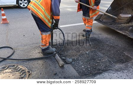 A Brigade Of Servants For Road Maintenance Removes The Old Asphalt With A Jackhammer And Shovels Int