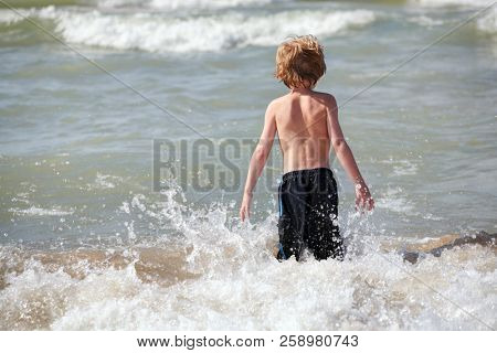 Boy playing in the waves at the beach