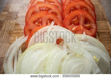 Red Tomato With Bow Slices On Chopping Board