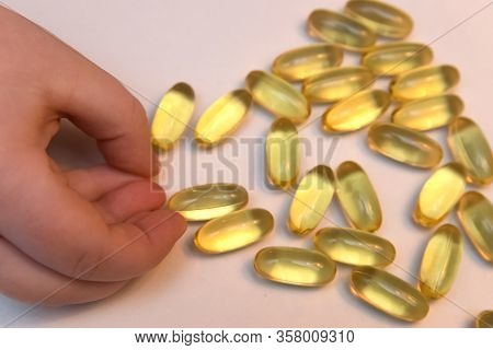 Vitaminen Omega 3 Fish Oil In Capsules In Hand On Beige Background.