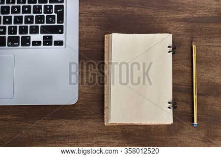 Laptop On A Wooden Table With Old Agenda