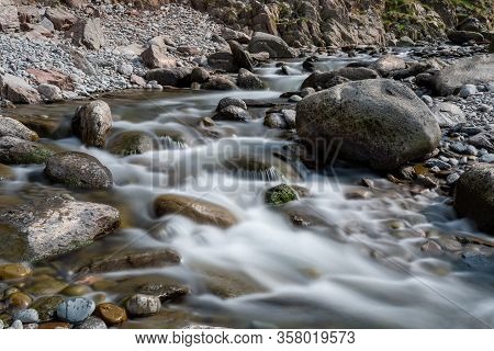 Long Exposure Of The River Flowing Over The Rocks On The Beach At Heddons Mouth In Exmoor National P