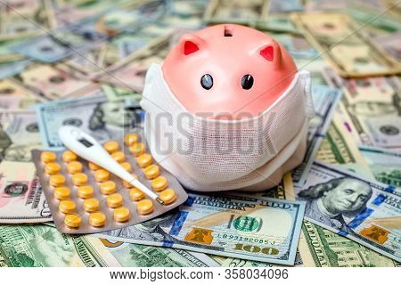 Piggy Bank In A Mask On A Background Of American Currency.the Concept Of Coronavrius Epidemic