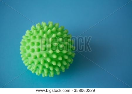 Close Up Of Green Spiky Coronavirus Model Isolated On Blue Background. Pandemic Desease Spreading Wo