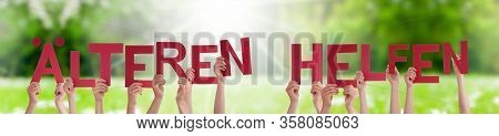 People Hands Holding Word Aelteren Helfen Means Help Elderly, Grass Meadow
