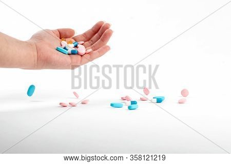 White plastic bottle with medicines and vitamines. tematic health. rose, yellow and red medicines.