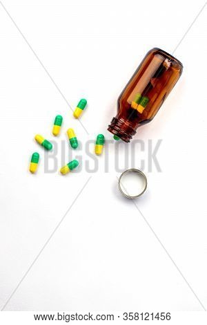 Glass Bottle With Medicines And Vitamins Inside. Green And Yellow Pills. Cap Bottle And Health Temat