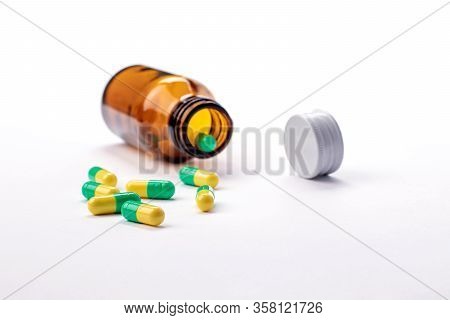 Glass Bottle With Medicines And Vitamins Inside. Green And Yellow Pills. Cap Bottle And Health Temat