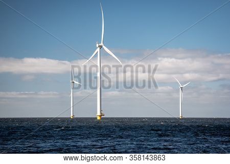 Offshore Windmill Farm In The Ocean Westermeerwind Park , Windmills Isolated At Sea On A Beautiful B