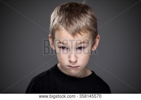 Grief-stricken little boy - feeling intense sorrow, remorse, sadnesss - studio portrait - vivid emotions series