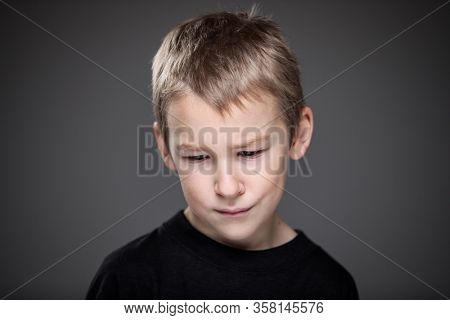 Grief-stricken little boy - feeling intense sorrow, remorse, sadnesss - studio portrait - vivid emotions series