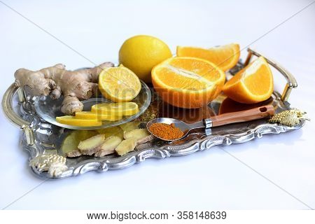 Ginger, Lemon, Oranges And Spices On A Metal Tray On A White Background. Close-up