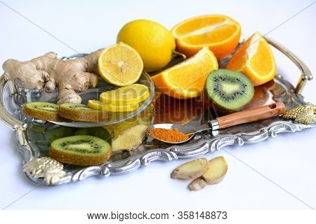 Lemons, Oranges, Kiwi, Ginger And Spices On A Metal Tray On A White Background. Close-up