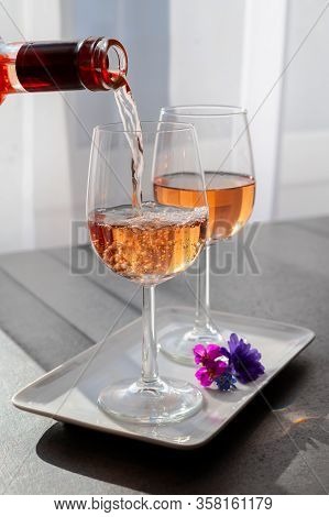 Pouring Of Rose Wine From Provence In Two Glasses In Sunny Day