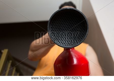 Man Aiming A Red Fire Extinguisher Towards The Camera