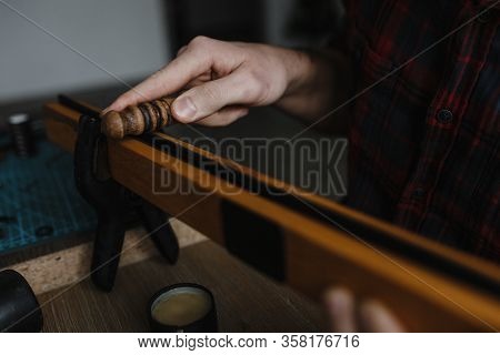 Man Hands Smoothing The Leather With The Special Wooden Instrument