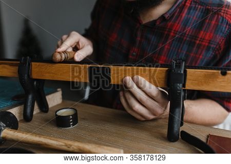 Man Hands Smoothing The Leather With The Special Instrument