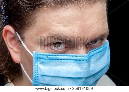 Male Portrait A Look From Under The Forehead A Close Up Of A Face With A Serious Expression In A Blu