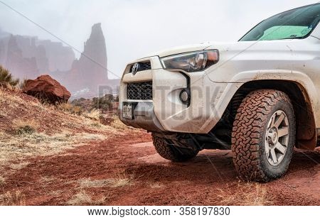 Moab , UT, USA - February 9, 2020:  Toyota 4runner SUV (2016 trail edition, stock vehicle) on a 4x4 trail in winter conditions with Fisher Towers in background.