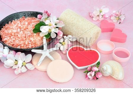 Vegan skincare spa beauty treatment with ex foliation and cleansing products with apple blossom flowers on pink background. Anti ageing health care concept.