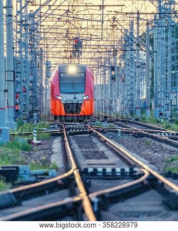 Highspeed Train Moves Throgh The Station At Sunset Time.