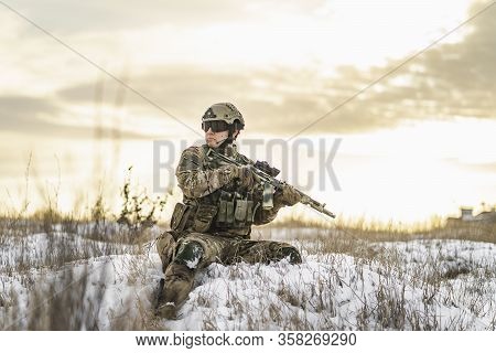 Modern Soldier In Multicam Camouflage Is Lying And Aiming Aim At The Sight. Full Equipment Commandos