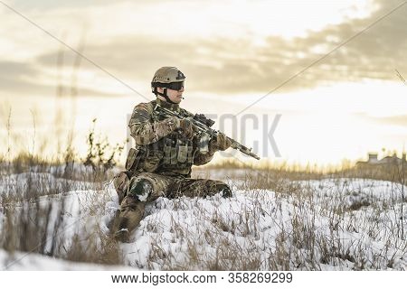 Modern Soldier In Multicam Camouflage Is Lying And Aiming Aim At The Sight. Full Equipment Commandos