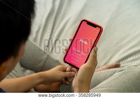 Bangkok, Thailand - March 27, 2020: A Man Holding A Phone With Screen Shot Of Tinder On Iphone. Tind