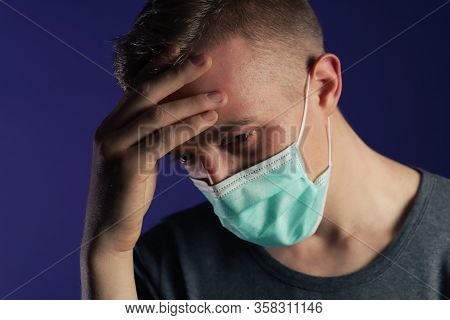Caucasian Man In A Medical Gause Mask With Palm On His Head.