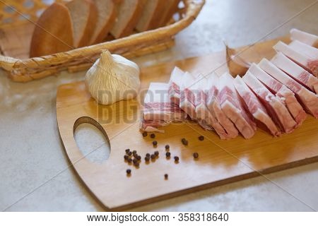 Studio Shot Of Traditional Ukrainian Food, Tasty Snack, Slices Of Lard, Garlic And Peppercorn Lying 