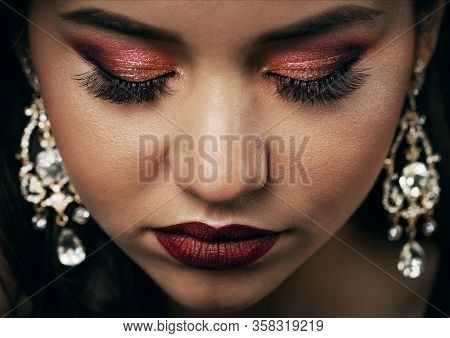 Close-up Top View Of Elegant Young Woman Face With Rich Make-up And Jewel Earrings, Closed Eyes