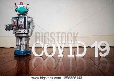 retro robot with text CIVID 19 on a old wooden floor 