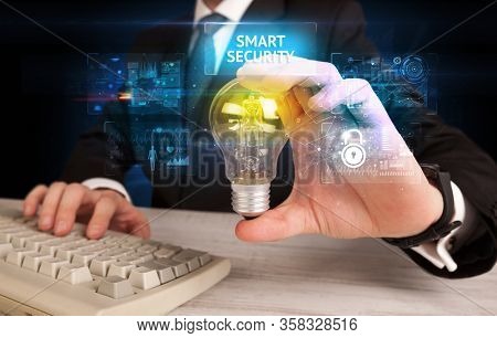 Businessman holding lightbulb with SMART SECURITY inscription, online security idea concept