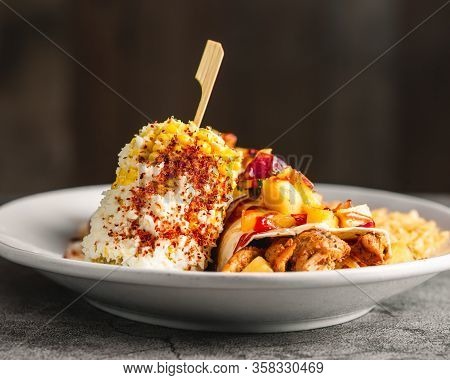 Beautifully Plated Chicken And Pineapple Burrito With Rice And Spicy Corn On The Cob 45 Degree Angle