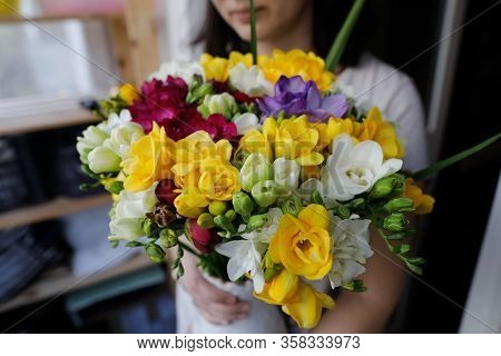 Shallow Depth Of Field Image (selective Focus) With A Woman Holding A Fresh Bouquet Of Freesias.