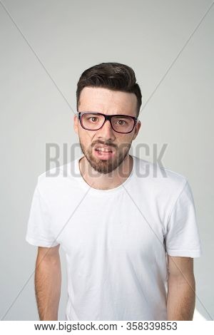 Young Man Isolated Over Background. Vertical Picture Of Nerd Or Weirdo Look Straight Through Glasses